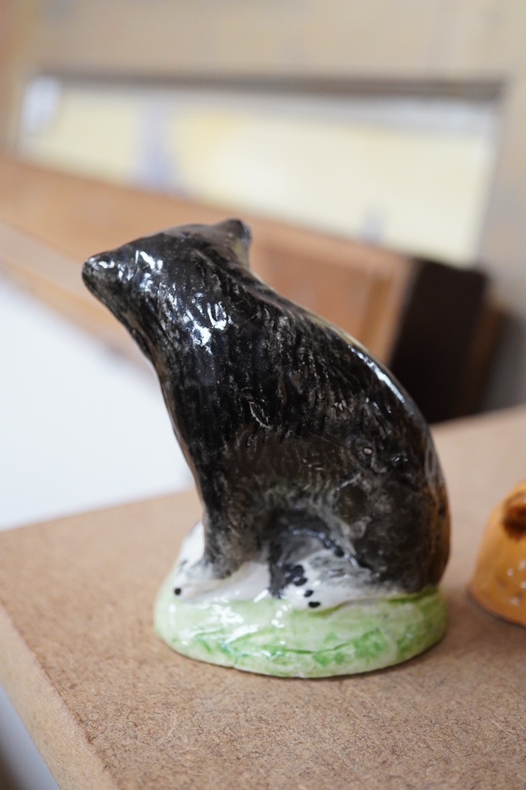 A Staffordshire Pearlware figure of a recumbent ewe, a Staffordshire glazed terracotta figure of a recumbent deer and a Staffordshire pearlware model of a badger?, largest 14cm wide